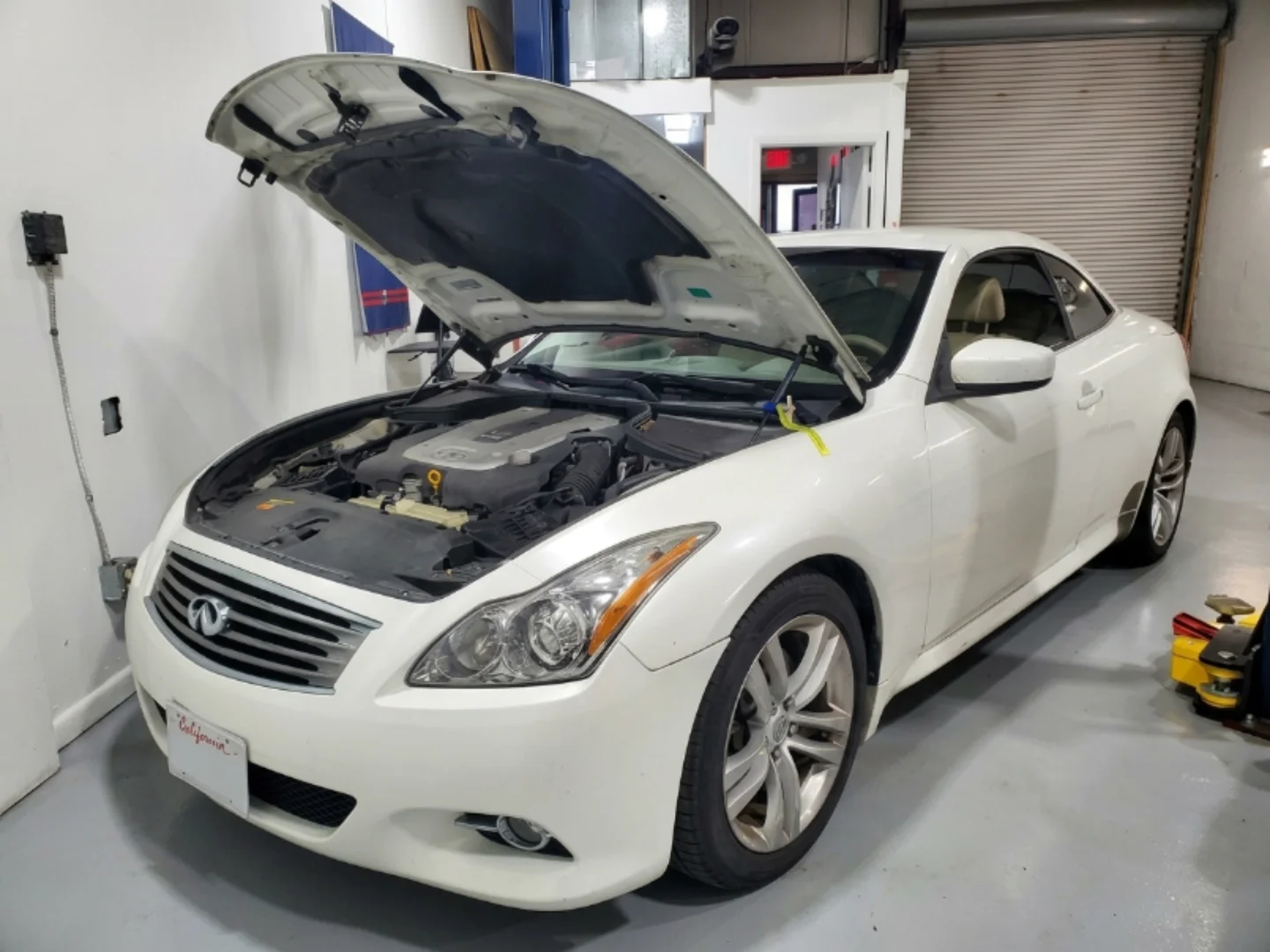 Infiniti technician running engine diagnostics in the Mussafah workshop